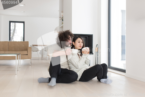 Image of happy multiethnic couple  in front of fireplace