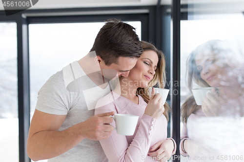 Image of young couple enjoying morning coffee by the window