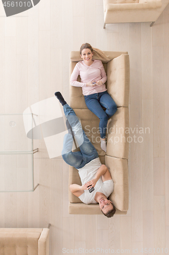 Image of Young couple on the sofa watching television top view