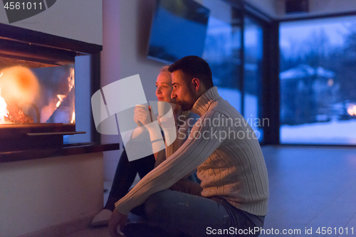 Image of happy couple in front of fireplace