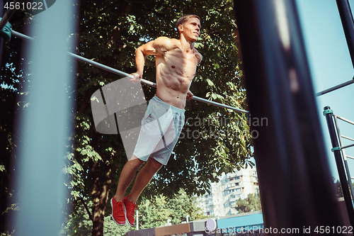 Image of Athlete doing exercises at stadium at park