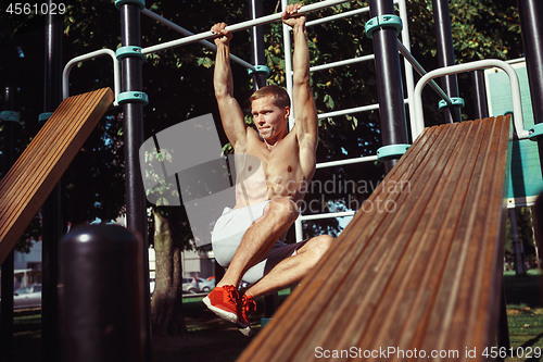 Image of Athlete doing exercises at stadium at park