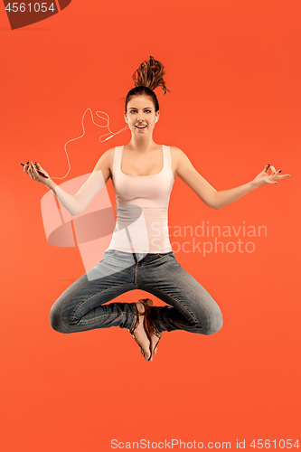 Image of Full length of pretty young woman with mobile phone while jumping