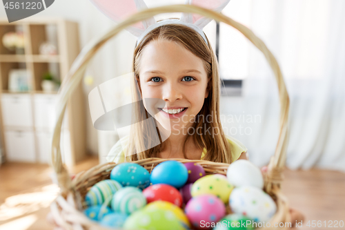 Image of happy girl with colored easter eggs at home