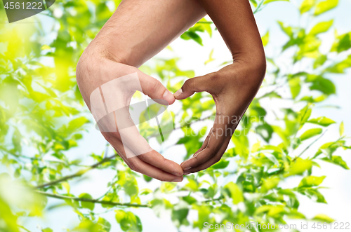 Image of hands of different skin color making heart shape