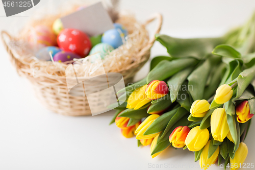 Image of close up of colored easter eggs and tulip flowers