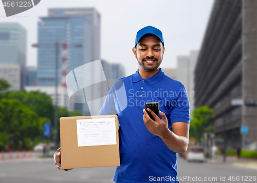 Image of indian delivery man with smartphone and parcel box