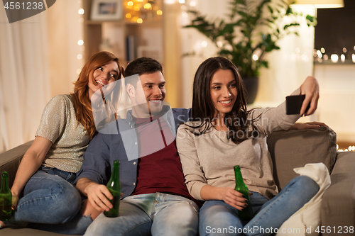 Image of happy friends taking selfie by smartphone at home
