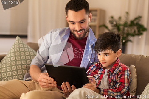 Image of father and son listening to music on tablet pc