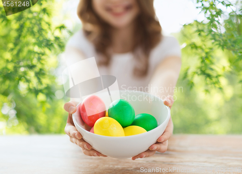 Image of close up of girl with bowl of colored easter eggs