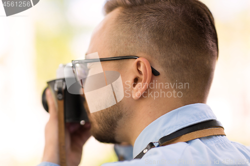 Image of photographer with film camera making shot