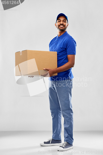 Image of happy indian delivery man with parcel box in blue