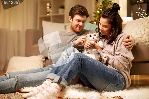 Image of happy couple with cat at home