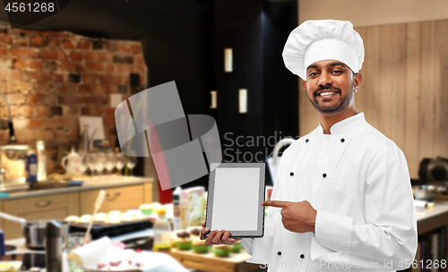 Image of happy indian chef with tablet computer at kitchen