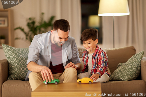 Image of father and son playing with toy cars at home