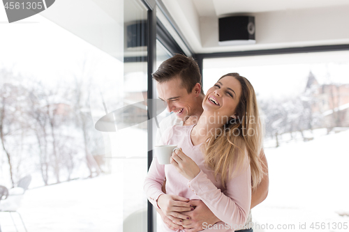 Image of young couple enjoying morning coffee by the window