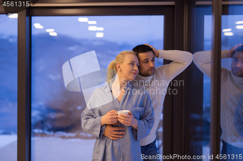 Image of young couple enjoying evening tea by the window