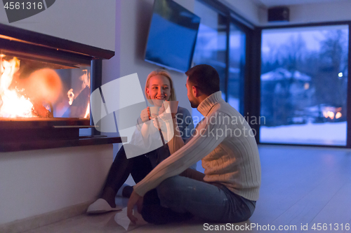 Image of happy couple in front of fireplace