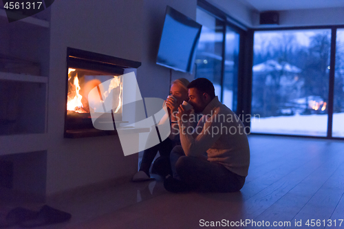 Image of happy couple in front of fireplace