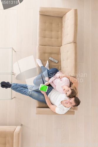 Image of young couple in living room using tablet top view