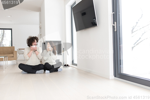 Image of happy multiethnic couple  in front of fireplace