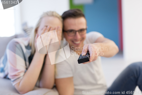 Image of Young couple on the sofa watching television