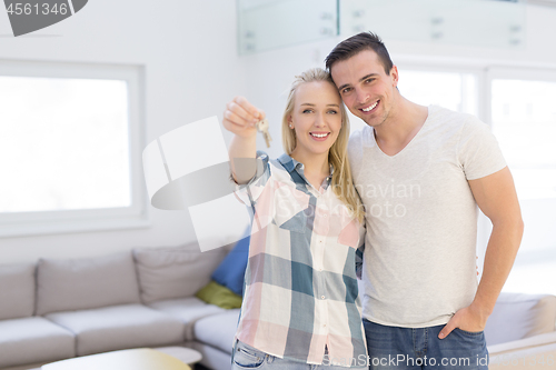 Image of couple showing a keys of their new house