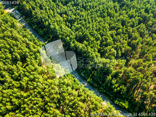 Image of Foliage green forest with asphalt road on sunny day, natural beautiful background. Aerial view from the drone