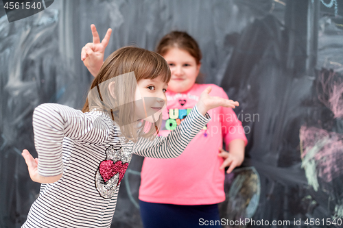 Image of little girls having fun in front of chalkboard