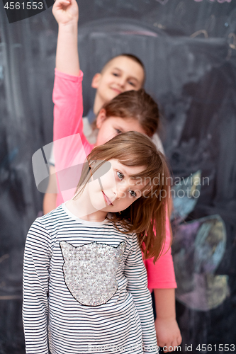 Image of group of kids standing in front of chalkboard