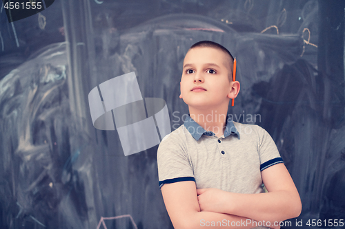 Image of portrait of little boy in front of chalkboard