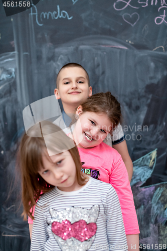 Image of group of kids standing in front of chalkboard