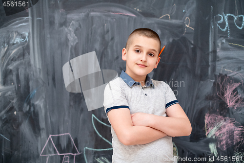 Image of portrait of little boy in front of chalkboard