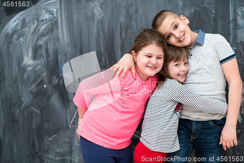 Image of group of kids hugging in front of chalkboard