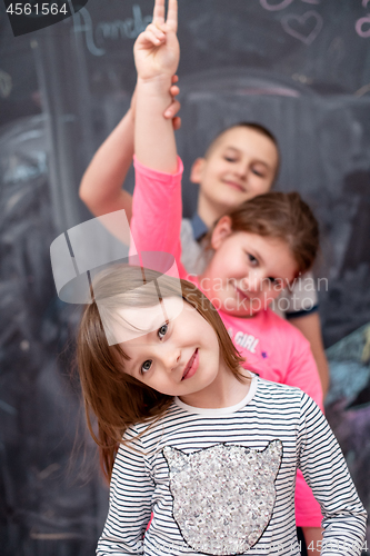 Image of group of kids standing in front of chalkboard