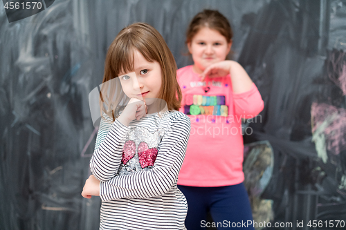 Image of portrait of little girls in front of chalkboard