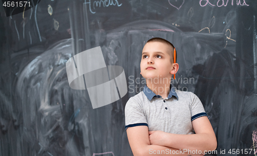 Image of portrait of little boy in front of chalkboard