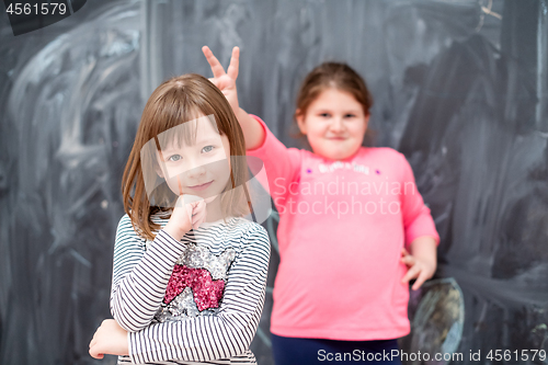 Image of little girls having fun in front of chalkboard