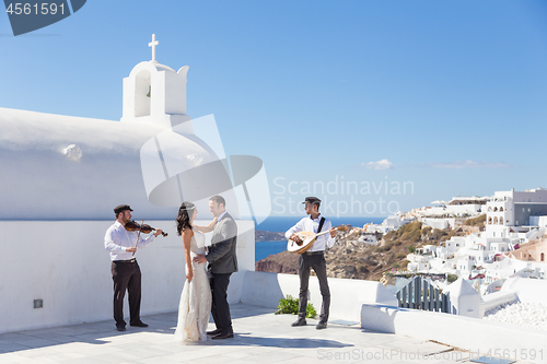 Image of Bride and groom dansing on wedding ceremony on Santorini island, Greece.