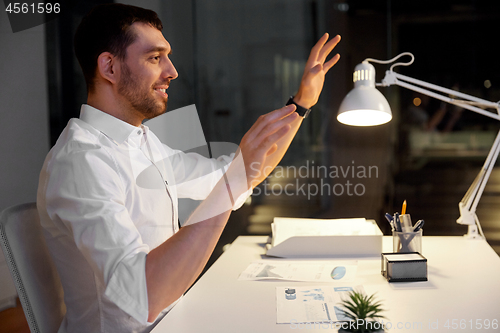 Image of businessman using gestures at night office