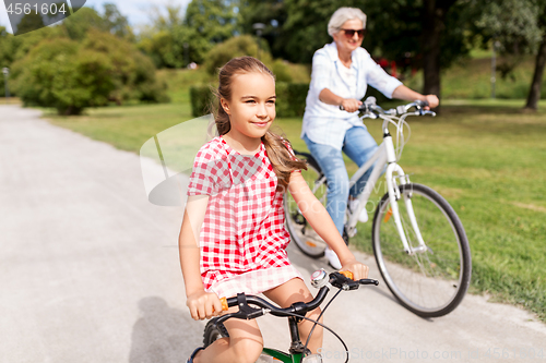 Image of grandmother and granddaughter cycling at park