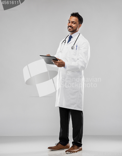 Image of smiling indian male doctor with tablet computer