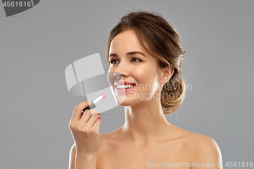 Image of woman with pink lipstick applying make up