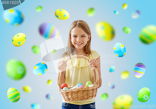 Image of happy girl with colored eggs in wicker basket