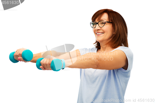 Image of smiling senior woman with dumbbells exercising