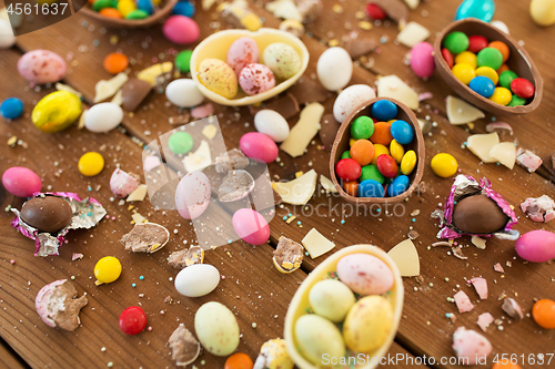 Image of chocolate eggs and candy drops on wooden table