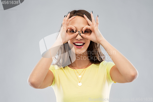 Image of young woman looking through finger glasses