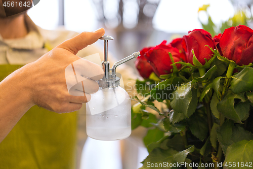 Image of florist or seller moistening roses at flower shop