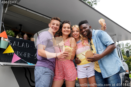 Image of happy friends with wok and burger at food truck