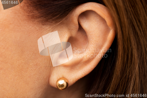 Image of close up of senior woman ear with golden earring